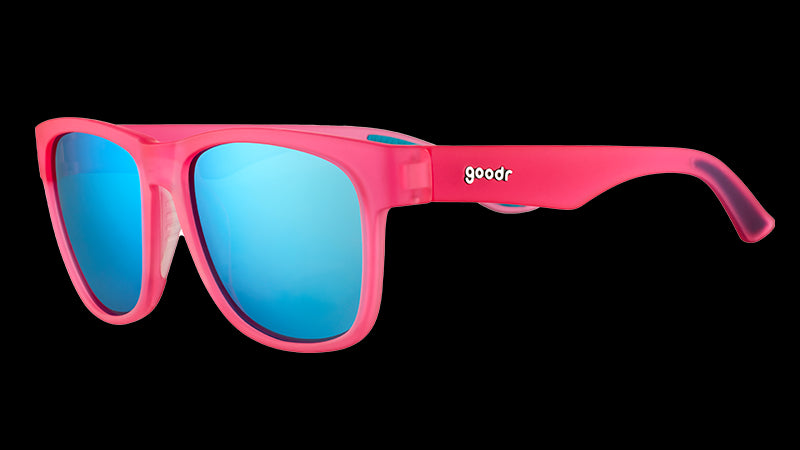 Driekwartaanzicht van een vierkante, brede roze zonnebril met blauwe, reflecterende glazen.